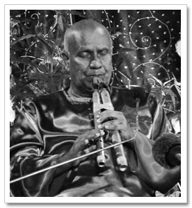 Sri Chinmoy playing one of 74 flutes